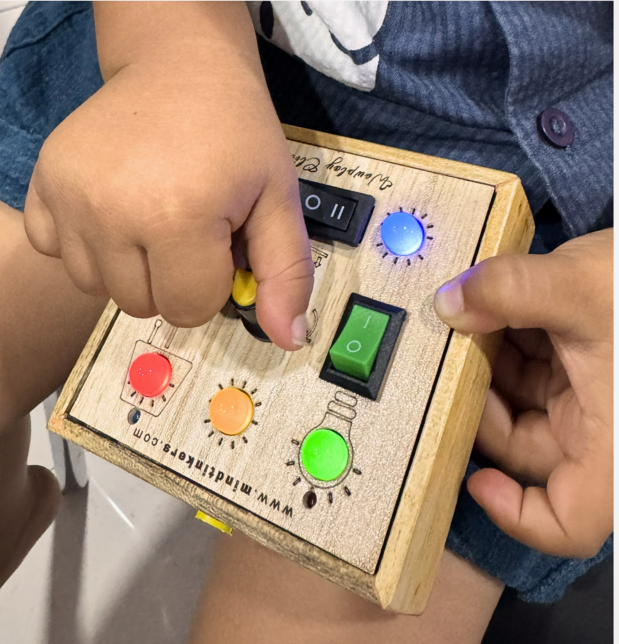 Colourful LED lights glowing on the busyboard as a toddler plays