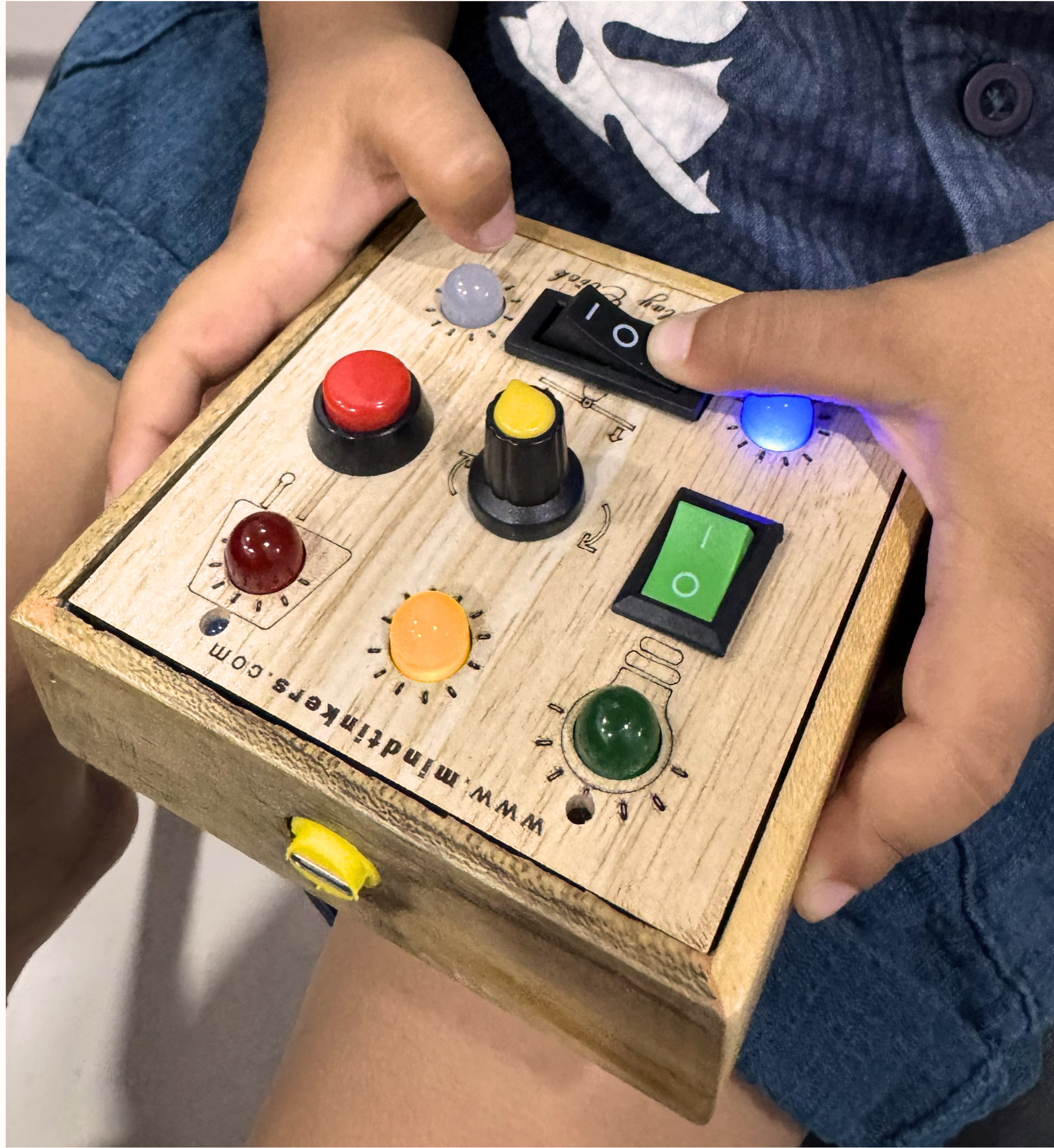 Close-up of a toddler's hand sliding a control on the busyboard
